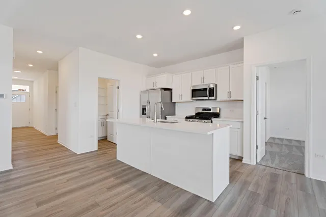 a kitchen with a refrigerator and a stove top oven