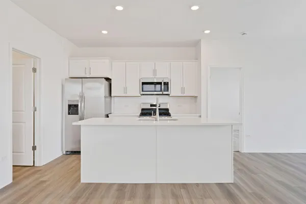 a kitchen with stainless steel appliances a microwave a sink and a refrigerator