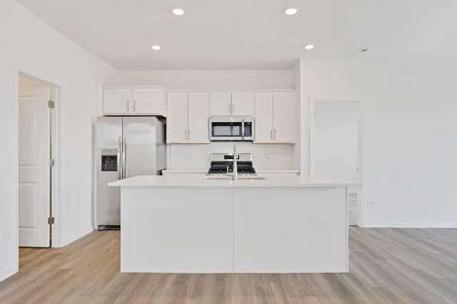a kitchen with stainless steel appliances a microwave a sink and a refrigerator