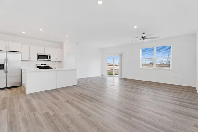 a view of a kitchen with wooden floor and electronic appliances