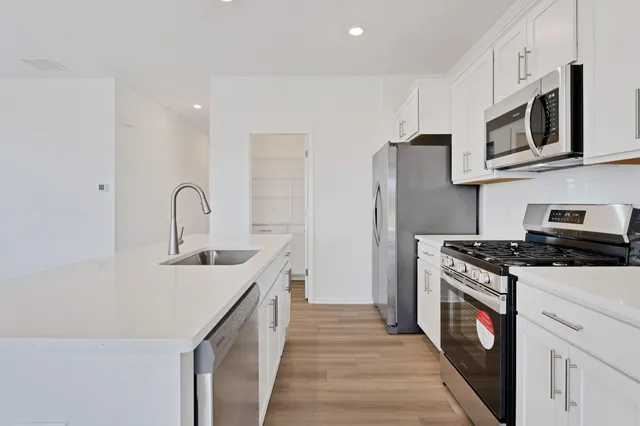 a kitchen with stainless steel appliances granite countertop a sink stove and refrigerator