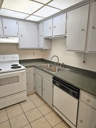 a kitchen with cabinets appliances a sink and a counter top