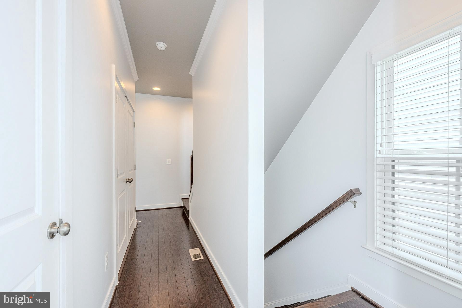 42298 Impervious Terrace Brambleton, VA 20148 - Photo 20 of 39 a view of a hallway with wooden floor and staircase