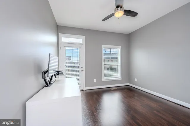 a view of an empty room with window and wooden floor