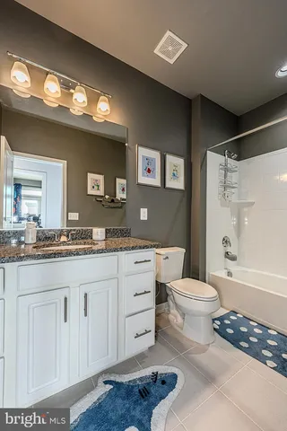 a spacious bathroom with a toilet a sink and a large mirror