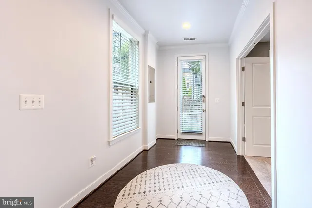 an entryway with a window and wooden floor