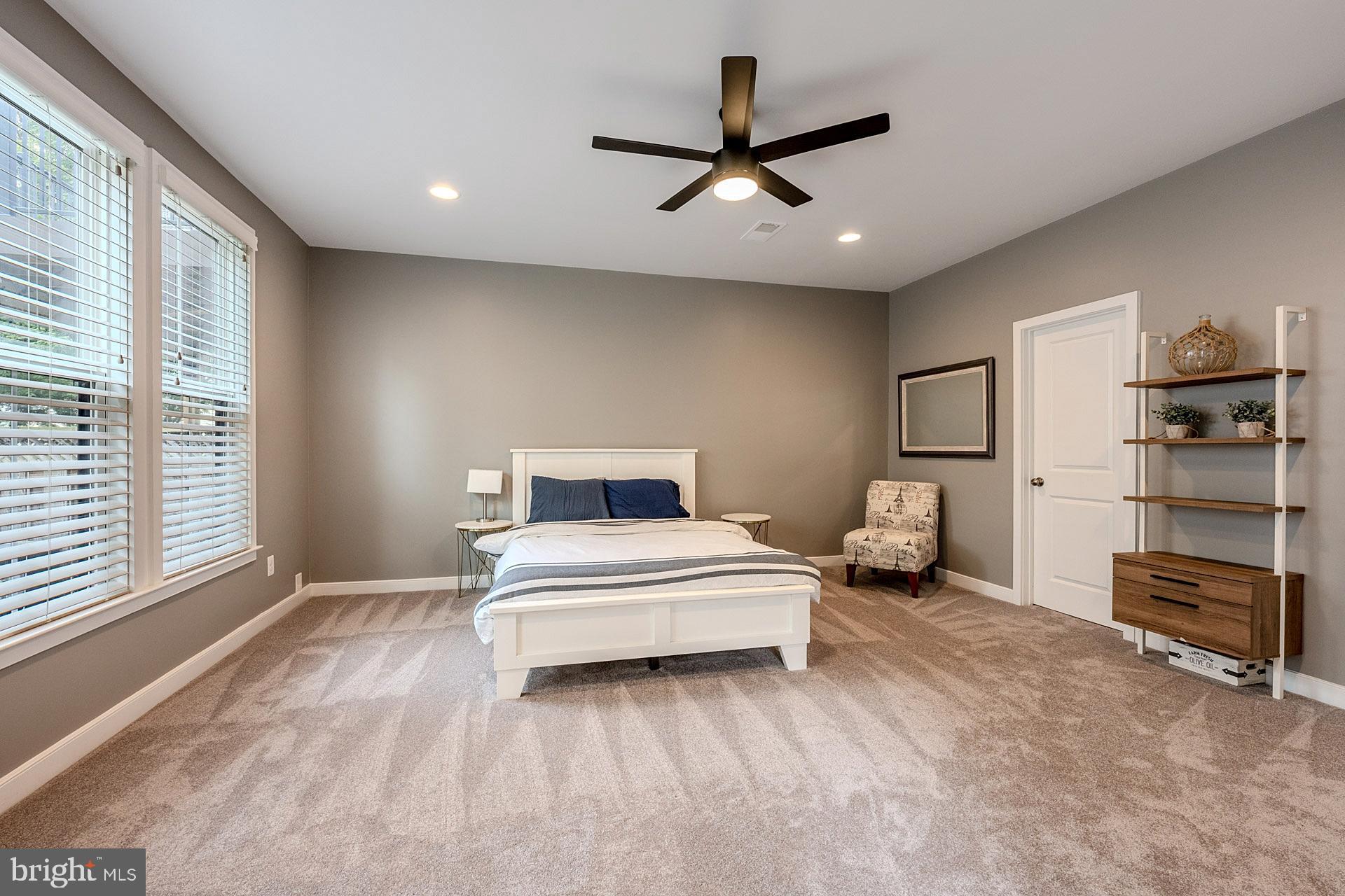 42298 Impervious Terrace Brambleton, VA 20148 - Photo 32 of 39 a spacious bedroom with a bed and a ceiling fan