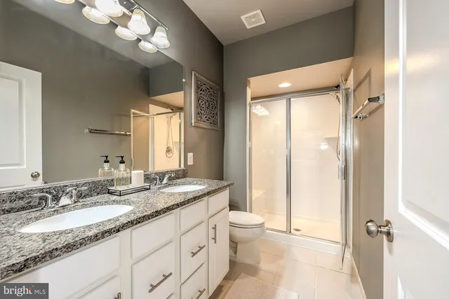 a bathroom with a granite countertop sink toilet and shower
