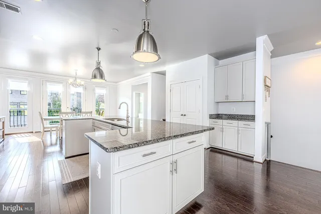 a kitchen with stainless steel appliances granite countertop a lot of counter space and wooden floors