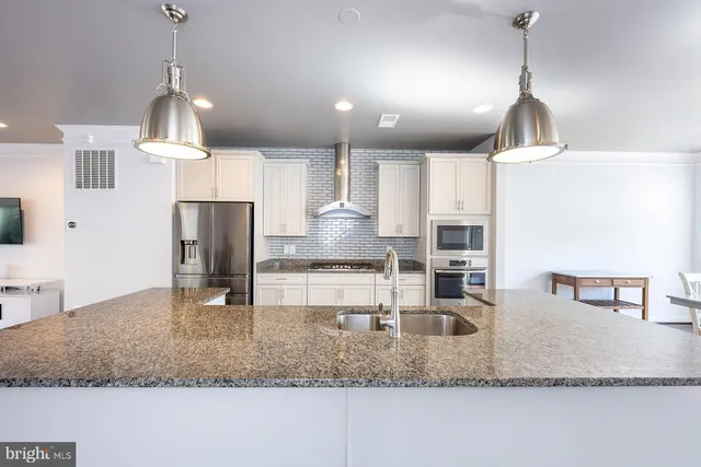 a kitchen with kitchen island granite countertop a sink a counter and cabinets