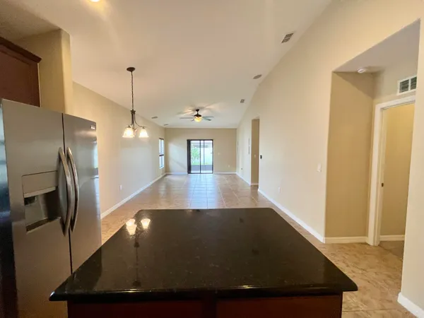 an empty room with a window and ceiling fan