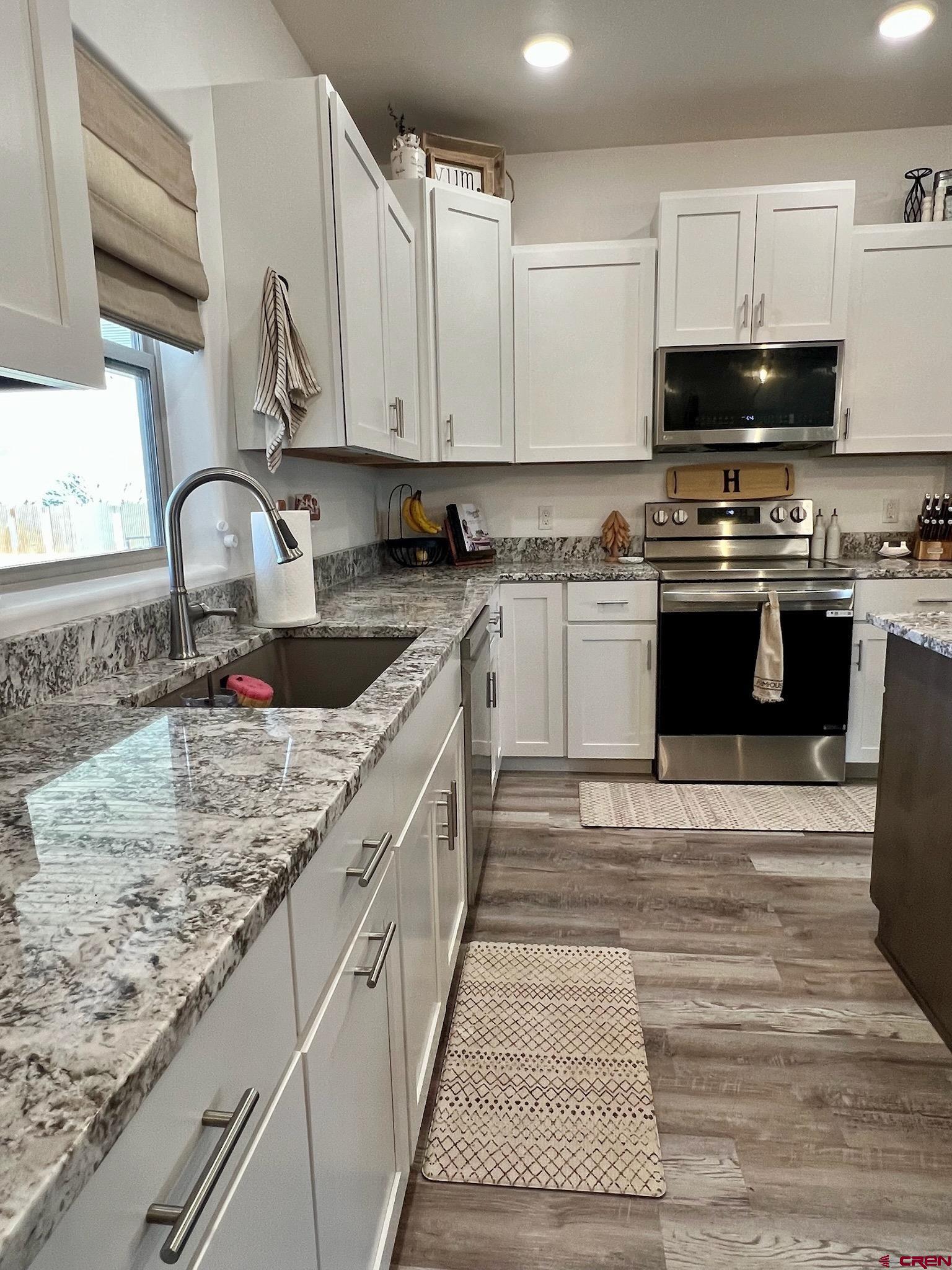 1780 Roubideau Street Delta, CO 81416 - Photo 9 of 34 a large kitchen with granite countertop a stove and a sink