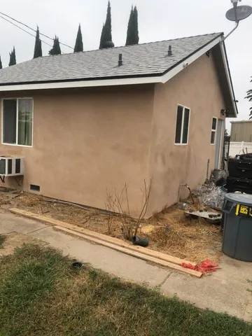 a front view of a house with a tree