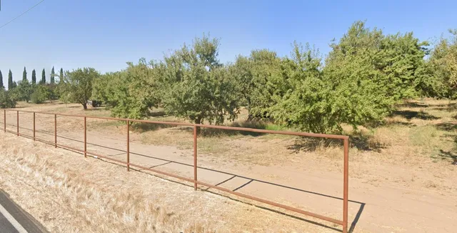 a view of a yard with wooden fence