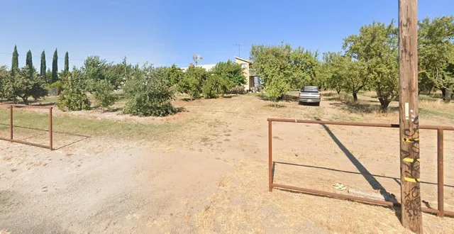 a view of field with trees in background