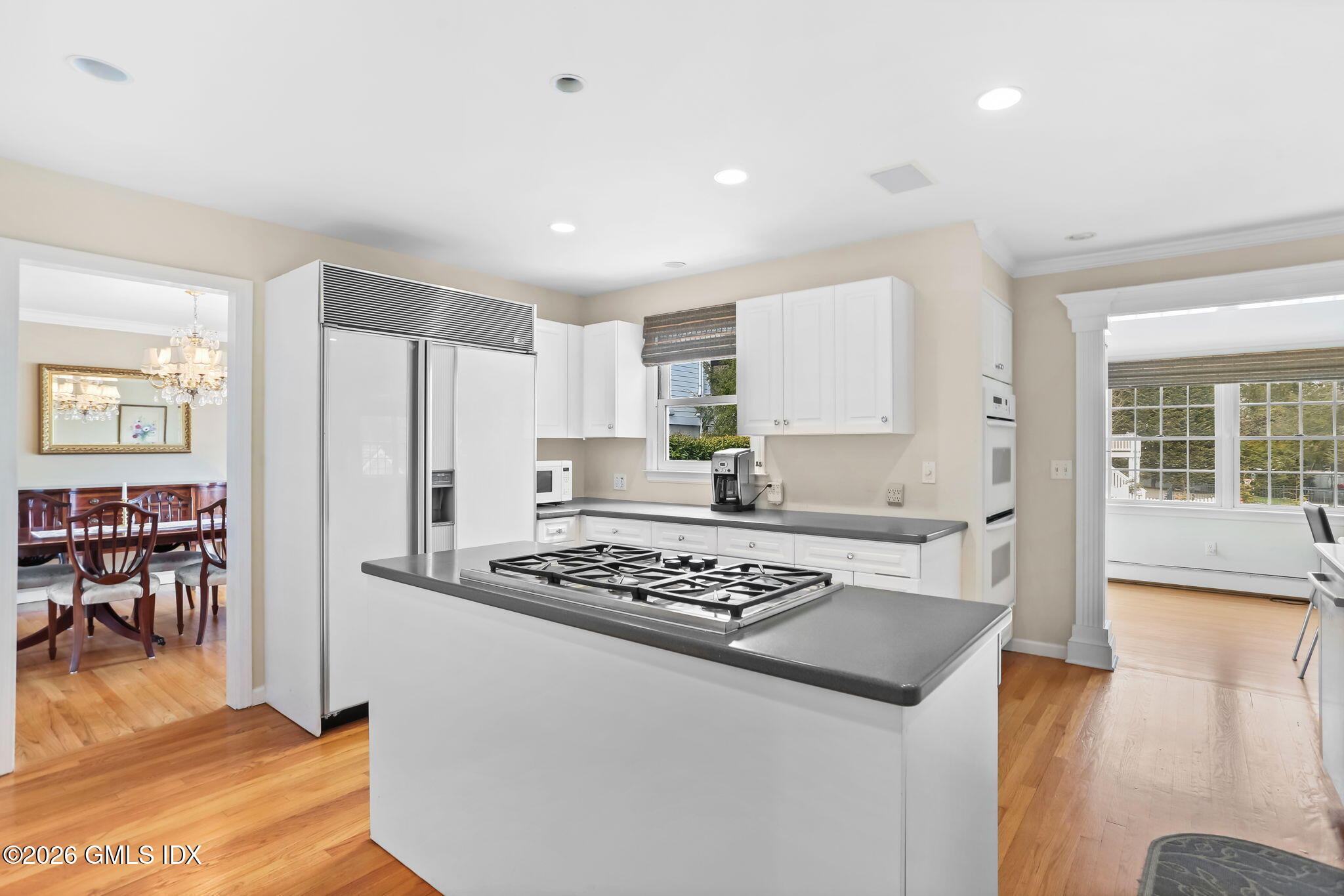 153 Lockwood Road Riverside, CT 06878 - Photo 15 of 58 a kitchen with stainless steel appliances granite countertop a refrigerator a stove and white cabinets with wooden floor