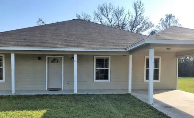 a front view of house with a garden