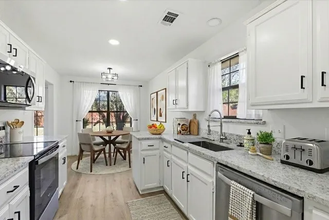 a kitchen that has a lot of cabinets in it and appliances