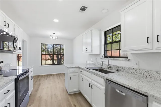 a kitchen with kitchen island a sink stainless steel appliances and cabinets