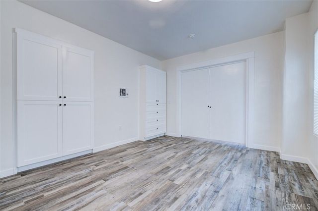 a view of cabinets with wooden floor and electronic appliances