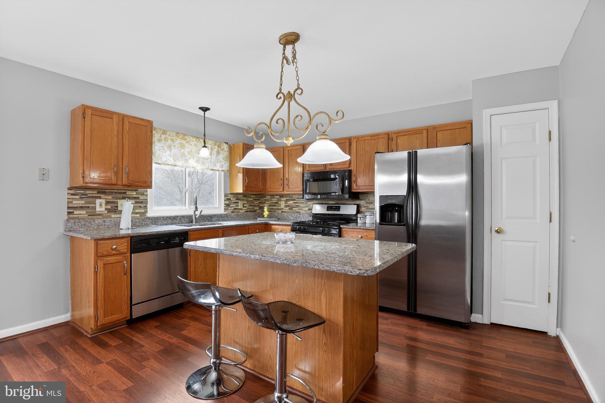 226 Finch Way Newark, DE 19702 - Photo 7 of 30 a kitchen with stainless steel appliances granite countertop a sink a stove and a wooden floors
