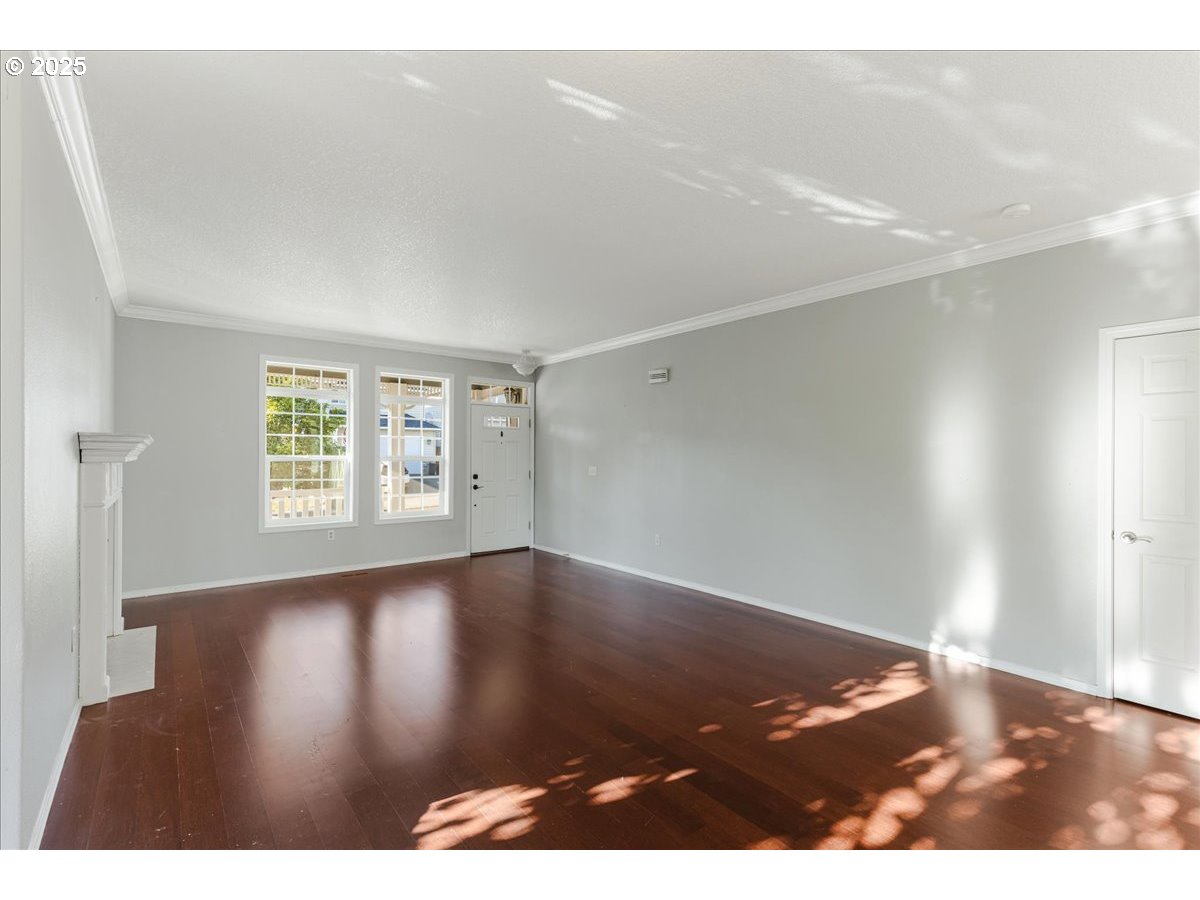 1807 North 8th Way Ridgefield, WA 98642 - Photo 4 of 44 a view of an empty room with wooden floor and a window