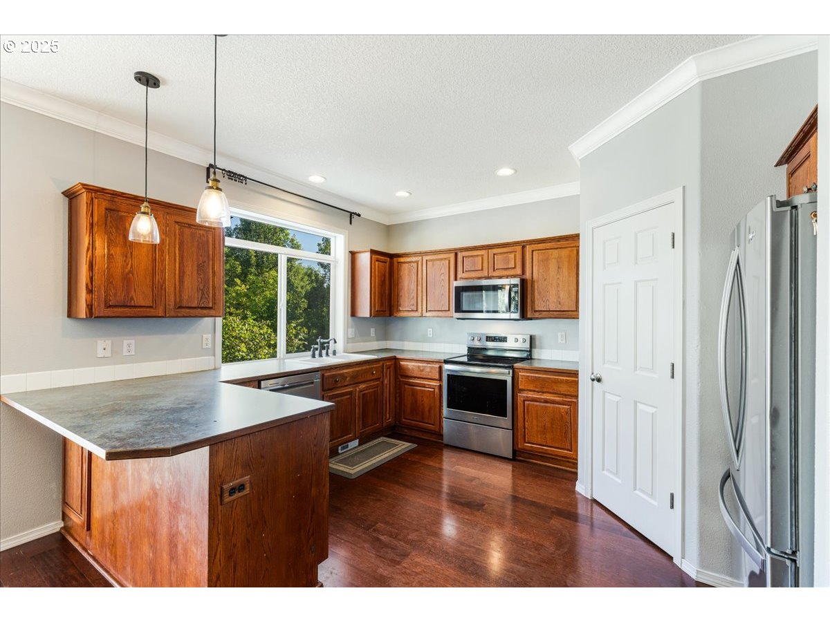1807 North 8th Way Ridgefield, WA 98642 - Photo 8 of 44 a kitchen with stainless steel appliances granite countertop a sink refrigerator and stove
