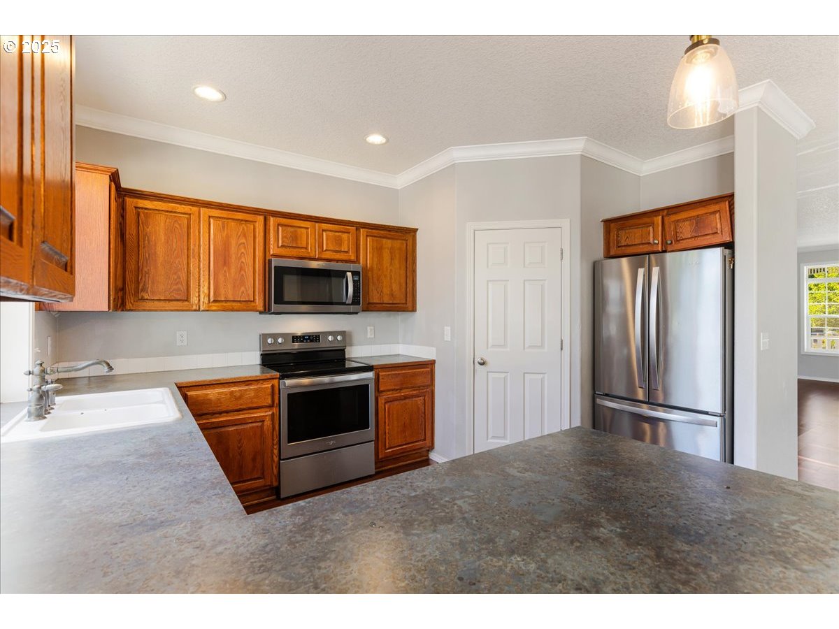 1807 North 8th Way Ridgefield, WA 98642 - Photo 10 of 44 a kitchen with stainless steel appliances granite countertop a refrigerator and a sink