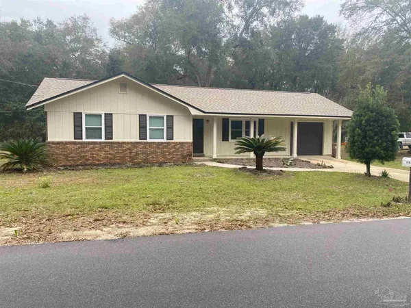 a front view of house with a yard and trees