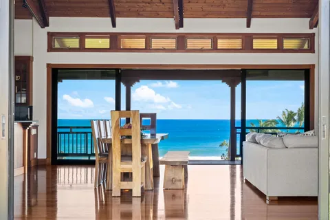 a living room with furniture a flat screen tv and a floor to ceiling window