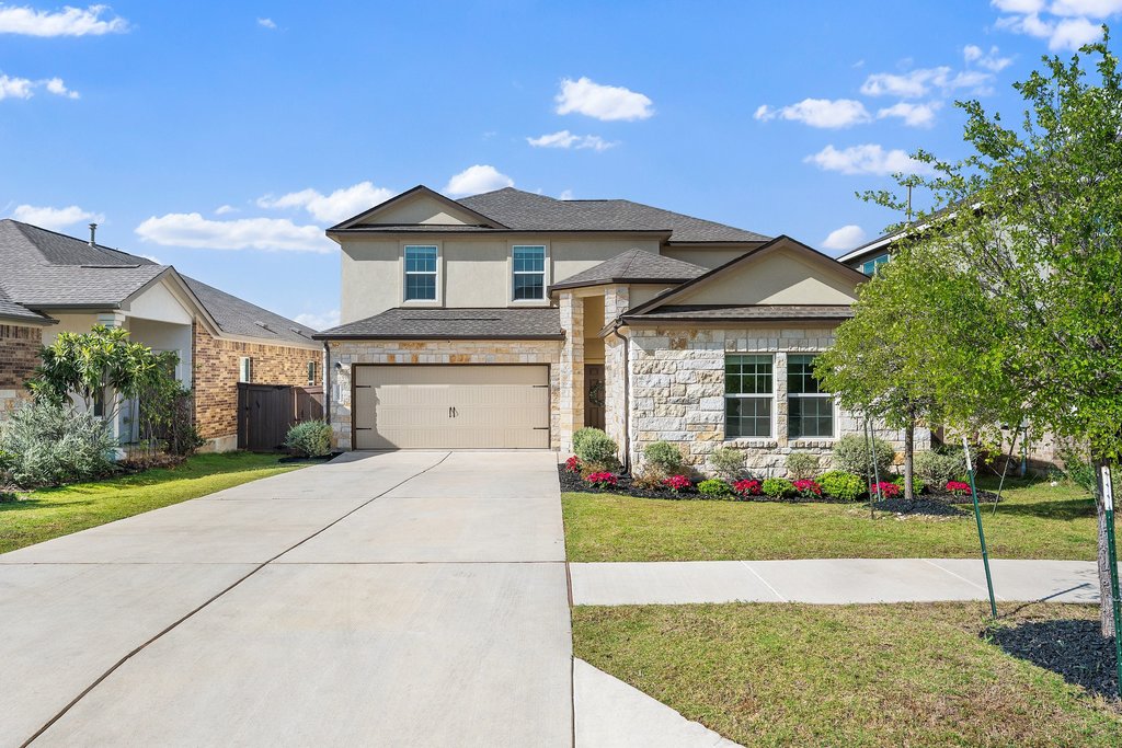 1233 Sweetspire Street Leander, TX 78641 - Photo 9 of 40 A striking two-story home with a stone and stucco facade, a spacious driveway and mature landscaping. Beautifully maintained 2023 home with attractive curb appeal and modern Hill Country styling.