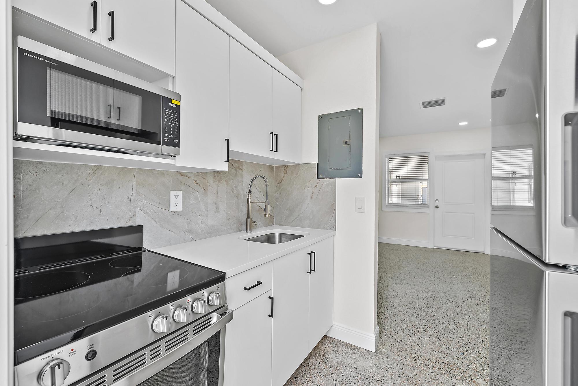 3808 Broadway Avenue West Palm Beach, FL 33407 - Photo 20 of 34 a kitchen with stainless steel appliances granite countertop a stove and a microwave