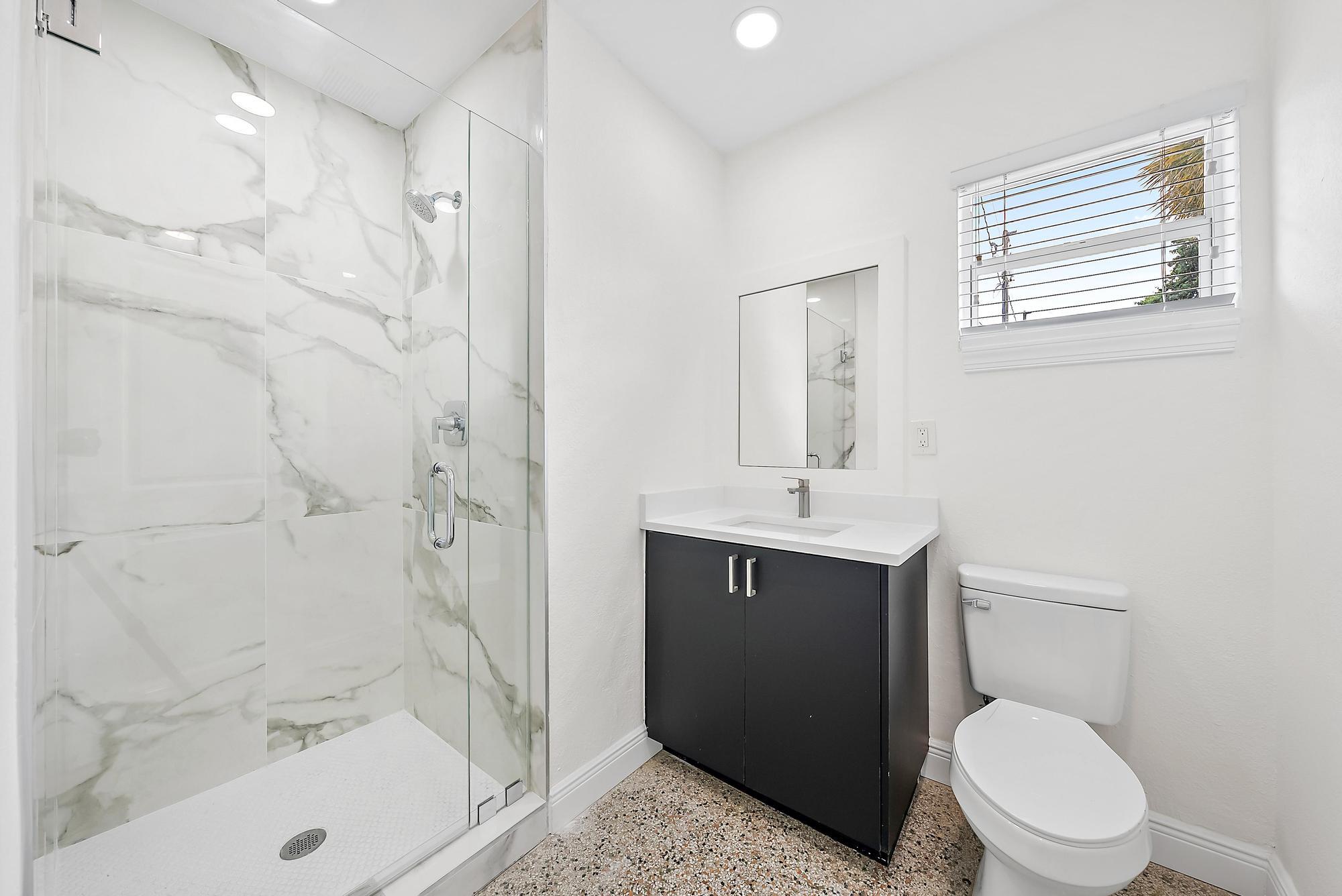3808 Broadway Avenue West Palm Beach, FL 33407 - Photo 23 of 34 a bathroom with a sink a toilet and shower