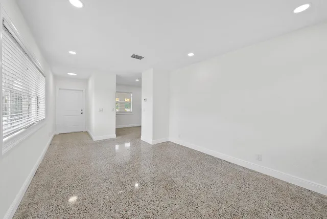 a kitchen with granite countertop a stove a sink and a refrigerator