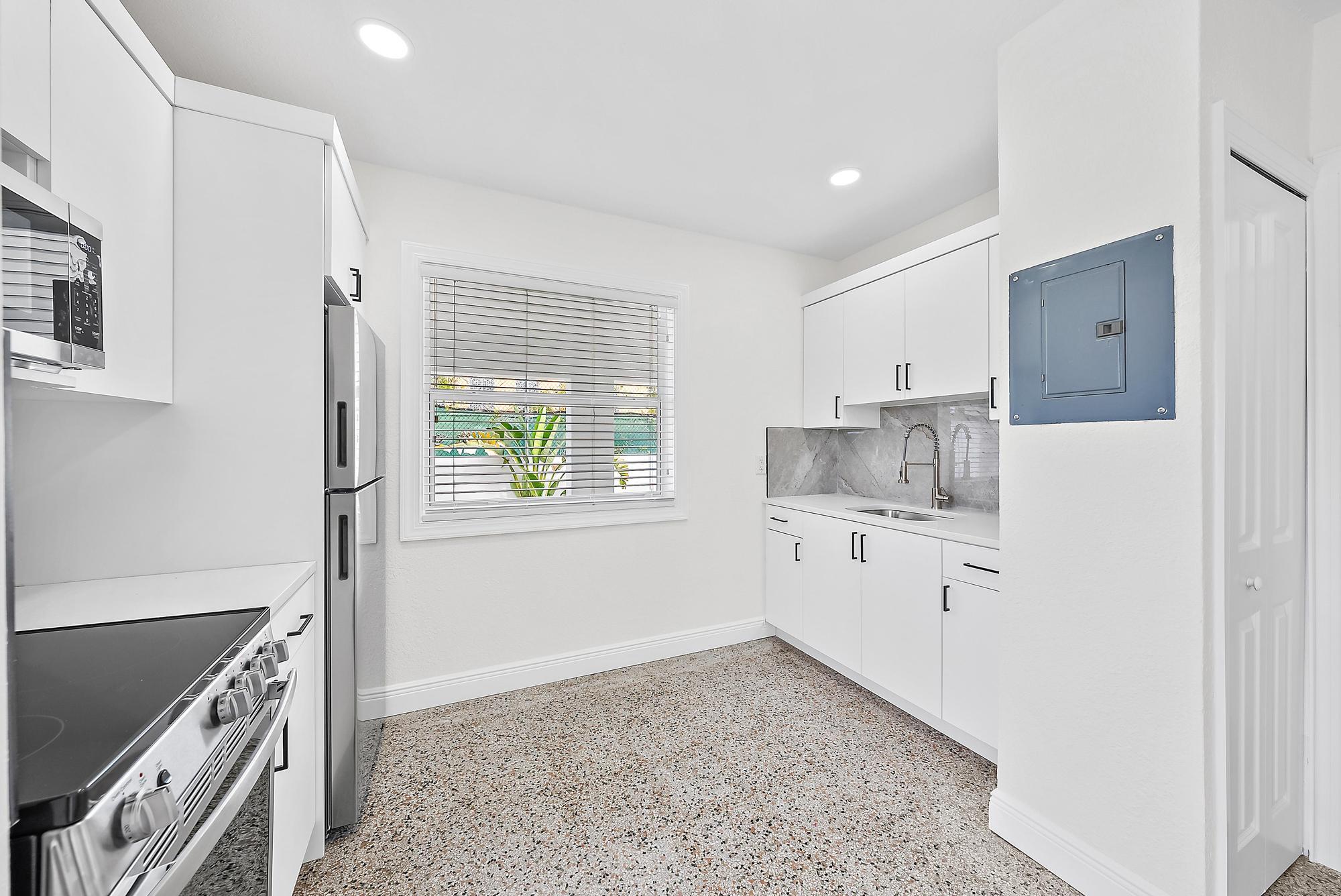 3808 Broadway Avenue West Palm Beach, FL 33407 - Photo 8 of 34 a kitchen with granite countertop a stove a sink and a refrigerator