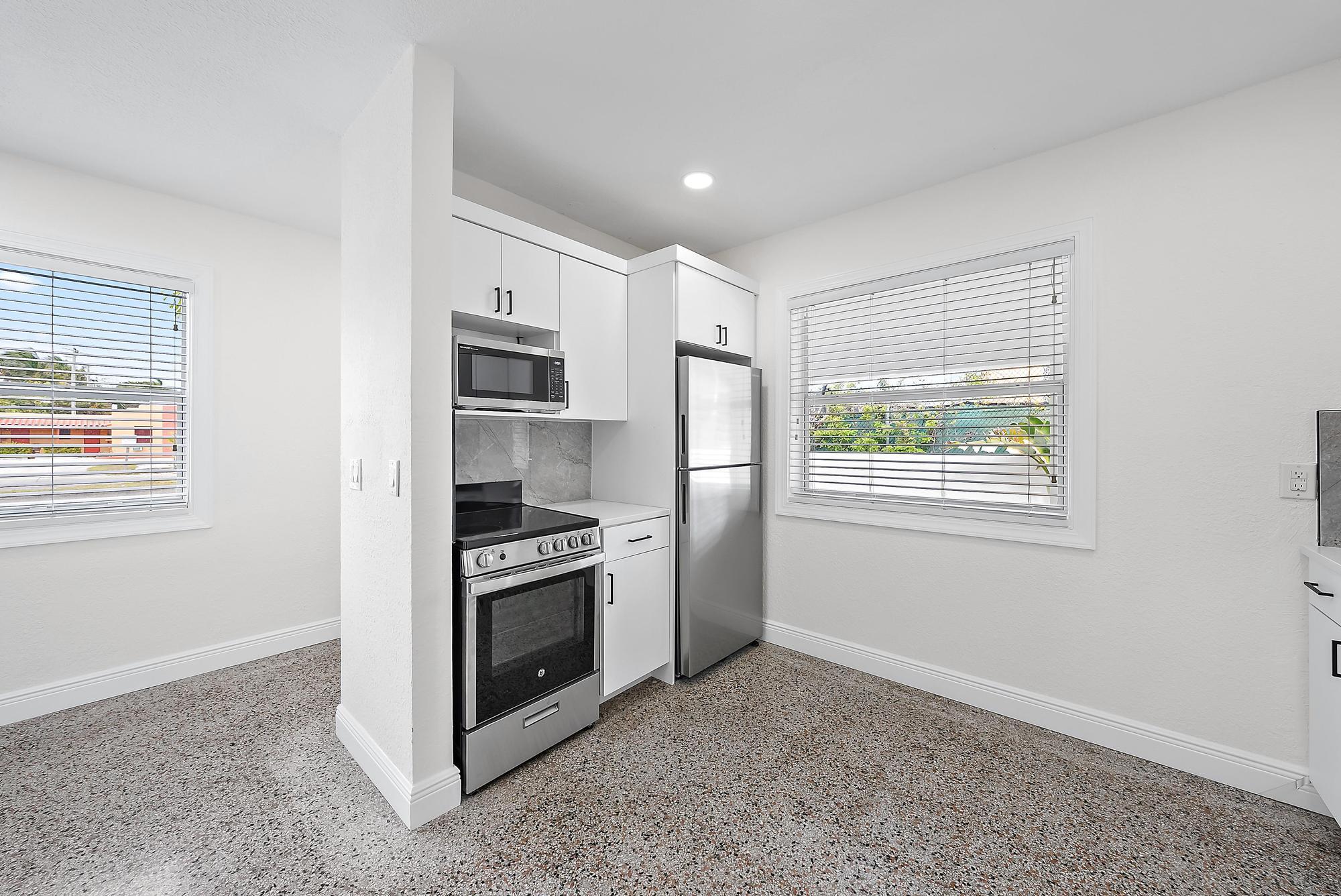 3808 Broadway Avenue West Palm Beach, FL 33407 - Photo 9 of 34 a kitchen with stainless steel appliances a stove a sink and a refrigerator