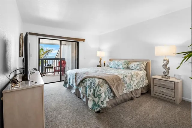 a bedroom with a balcony a bed and a flat screen tv