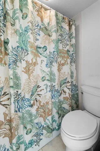 a white toilet sitting next to a shower curtain