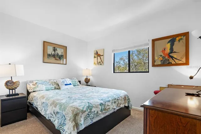 a bedroom with a bed and painting on the wall