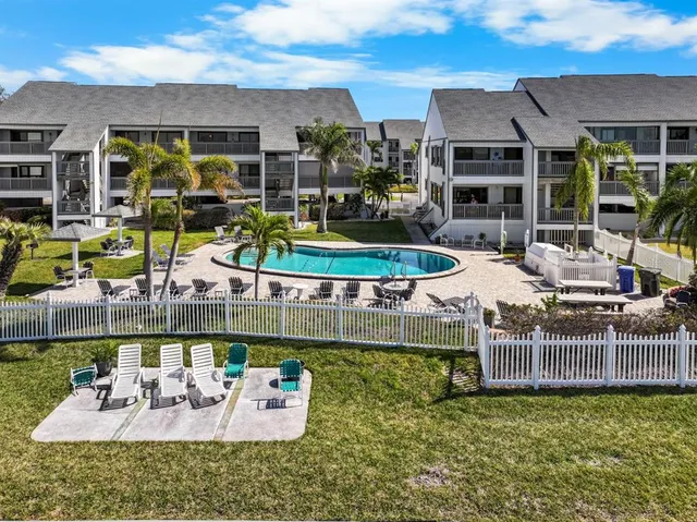 a view of a patio with couches table and chairs under an umbrella