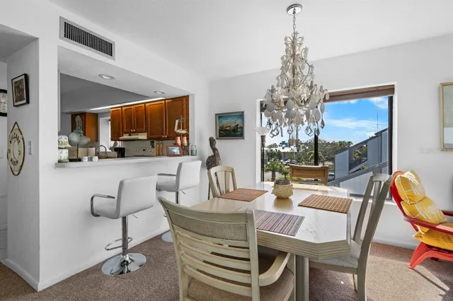 a dining room with furniture a chandelier and window
