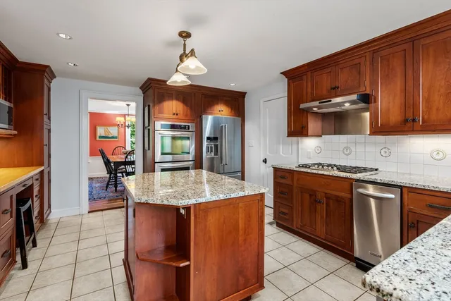 a kitchen with stainless steel appliances granite countertop wooden cabinets a sink and a stove