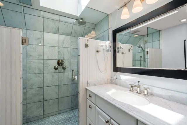 a bathroom with a sink shower and a mirror