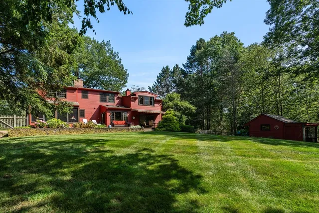 a view of a big house with a big yard and large trees