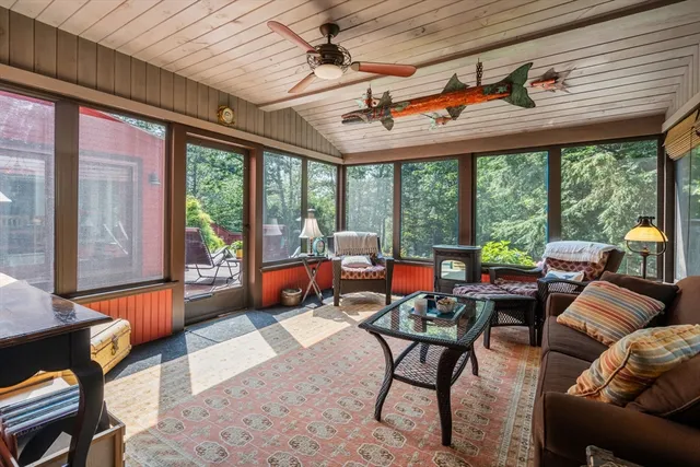 a living room with furniture a fireplace and a large window