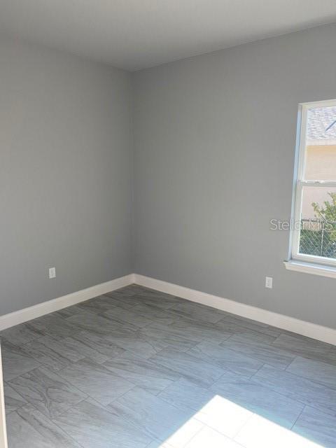 8 Llosee Court, Unit A Palm Coast, FL 32164 - Photo 11 of 21 a view of an empty room with wooden floor and a window