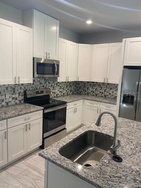 8 Llosee Court, Unit A Palm Coast, FL 32164 - Photo 4 of 21 a kitchen with stainless steel appliances kitchen island granite countertop a sink stove and cabinets