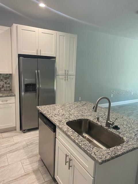 8 Llosee Court, Unit A Palm Coast, FL 32164 - Photo 5 of 21 a kitchen with granite countertop a sink and refrigerator