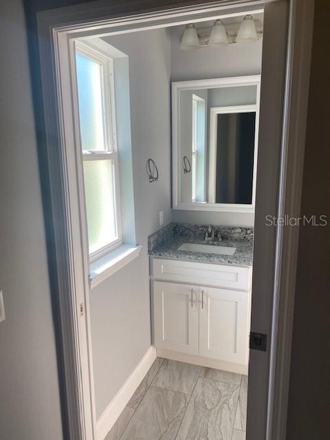 8 Llosee Court, Unit A Palm Coast, FL 32164 - Photo 8 of 21 a bathroom with a granite countertop sink and a mirror
