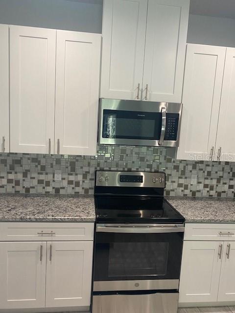 8 Llosee Court, Unit A Palm Coast, FL 32164 - Photo 9 of 21 a kitchen with granite countertop white cabinets and a stove